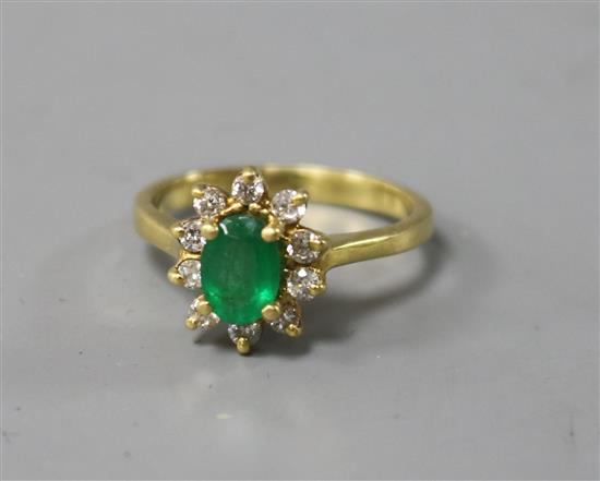 An 18ct gold, emerald and diamond oval cluster ring, size N.